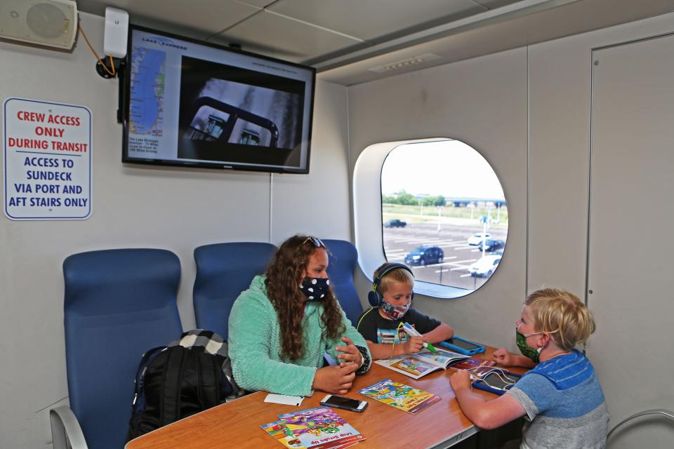 Riley Knox, from left, makes sure Tate Hayes, 5, and his brother Tripp, 8, have all their activity materials for their trip on the Lake Express ferry on Monday. The Lake Express launched its 2020 season.