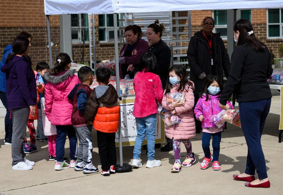 Children, some wearing face masks as a preventive measure, pick up free lunch at Kenmore Middle School in Arlington, Virginia on March 16, 2020, after schools in the area closed due to the coronavirus outbreak. - Stocks tumbled on March 16, 2020 despite emergency central bank measures to prop up the virus-battered global economy, as countries across Europe started the week in lockdown and major US cities shut bars and restaurants. The virus has upended society around the planet, with governments imposing restrictions rarely seen outside wartime, including the closing of borders, home quarantine orders and the scrapping of public events including major sporting fixtures. (Photo by ANDREW CABALLERO-REYNOLDS / AFP) (Photo by ANDREW CABALLERO-REYNOLDS/AFP via Getty Images)