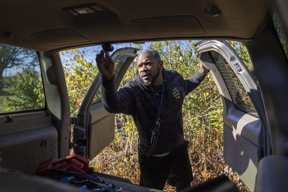 Jay Stewart adjusts his new rearview camera during an event where car cameras were distributed to drivers in an effort to combat a rise in crime, hosted in the parking lot of Robert F. Kennedy Stadium in Washington, Tuesday, Nov. 14, 2023. (AP Photo/Amanda Andrade-Rhoades)