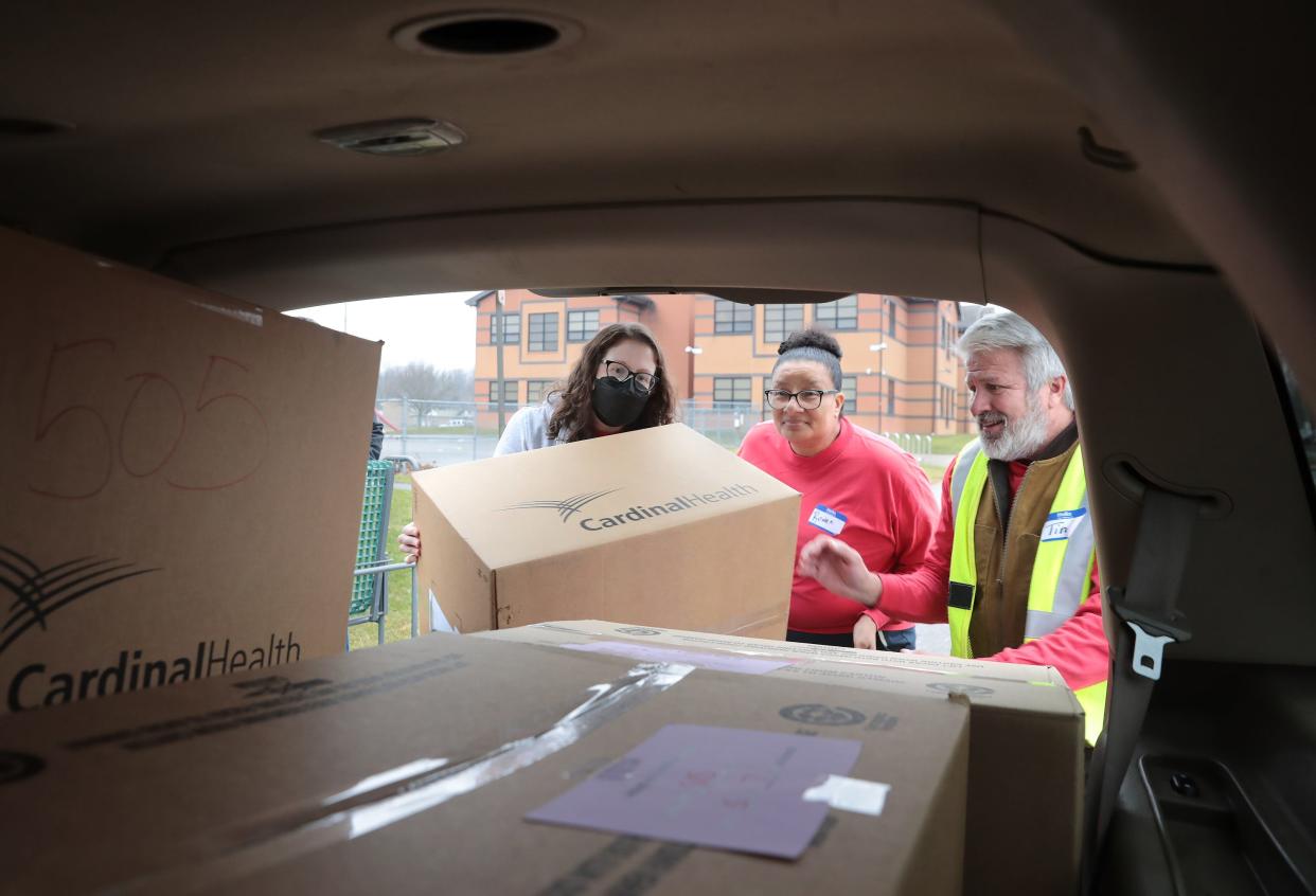 Dominion employees, from left, Colleen Cain, Renee Kelly and Tim Andrews load a recipient's car at the Southeast Community Center in Canton. For more than 30 years, Dominion Energy employees have adopted families identified through the program and donated clothing, toys, household items, cleaning products during the holidays.
