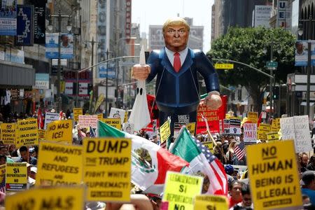 People march with an inflatable effigy of Republican presidential candidate Donald Trump during an immigrant rights May Day rally in Los Angeles, California, U.S., May 1, 2016. REUTERS/Lucy Nicholson