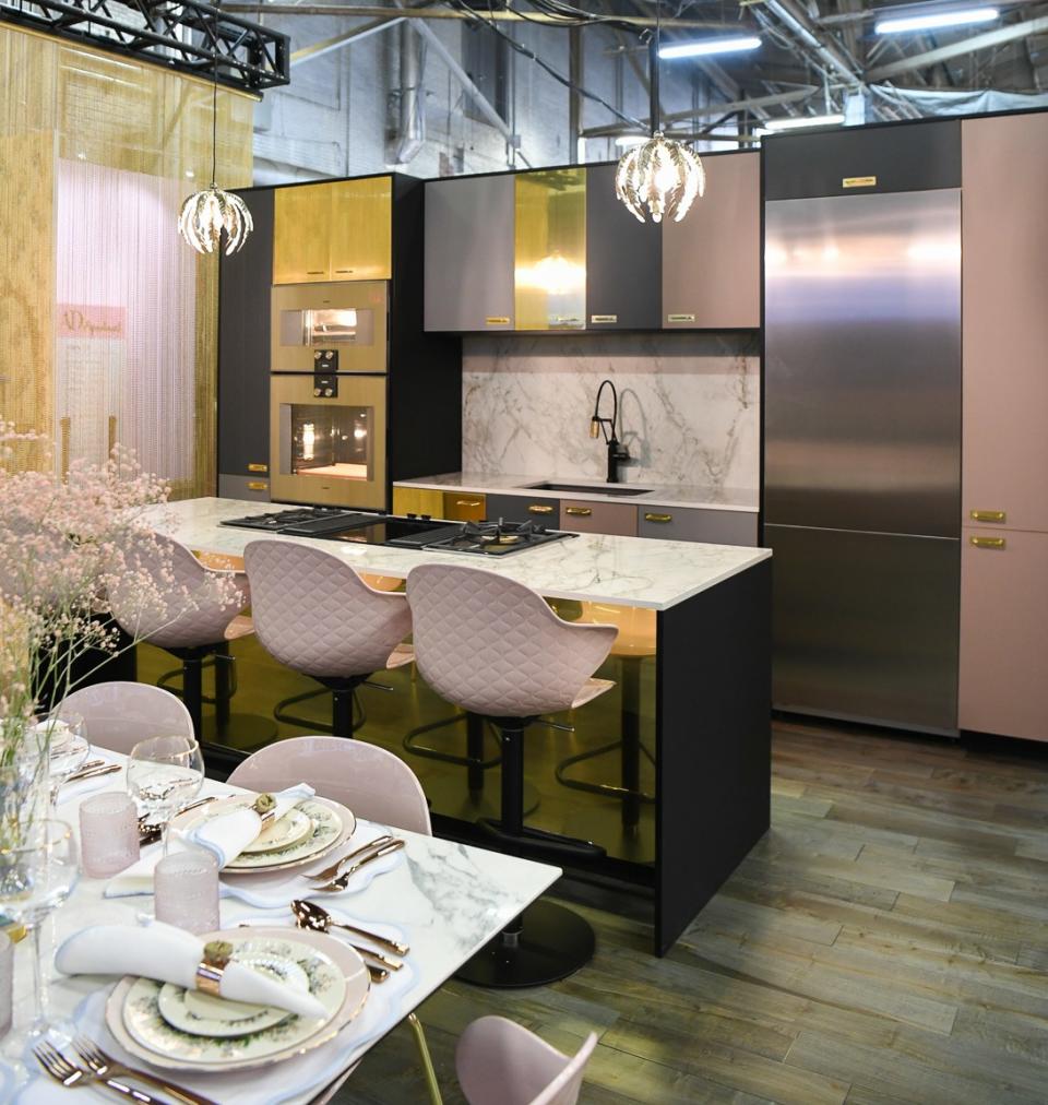 Brass, pink, and gray kitchen cabinets by Reform in the kitchen.