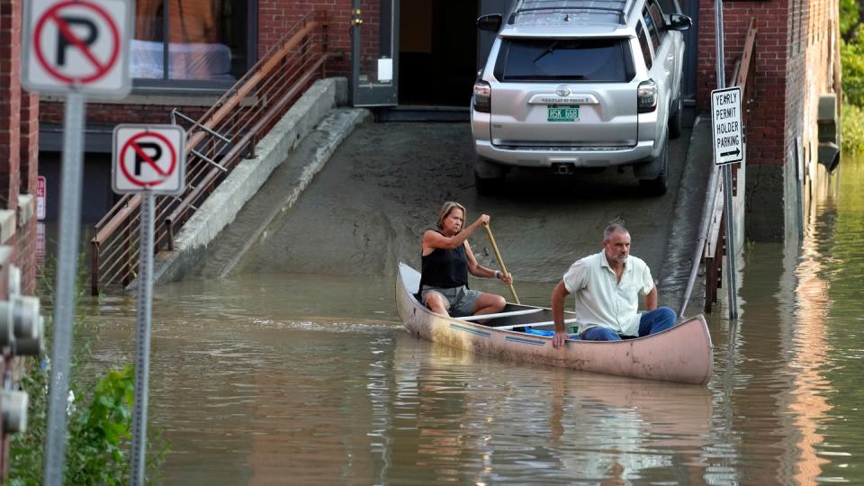 Anwohner versuchen, sich in einem Kanu in Sicherheit zu bringen. (Bild: Steven Senne / AP)