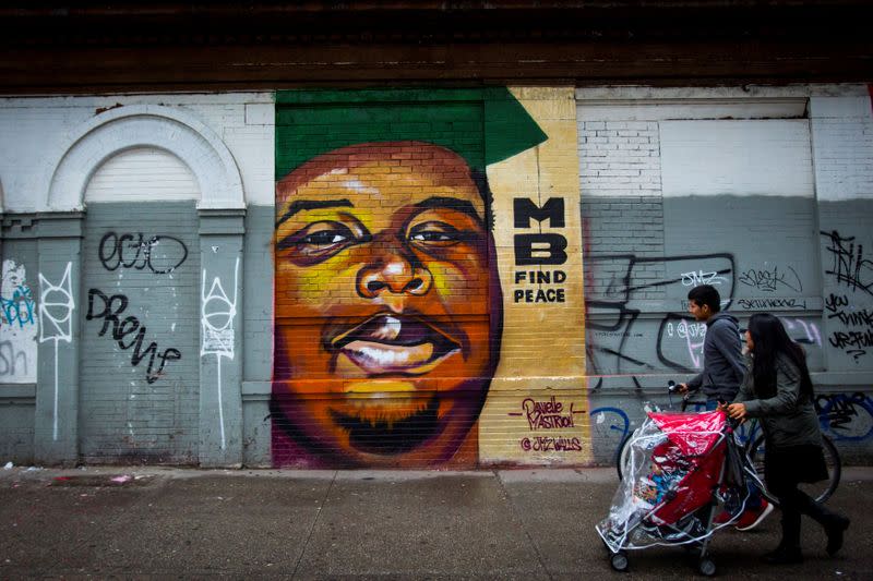 FILE PHOTO: People walk past a mural of Michael Brown in the Bushwick neighborhood of Brooklyn in New York