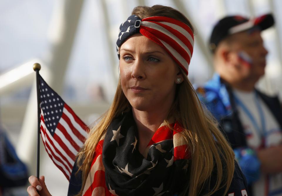 A fan carries a U.S. flag before the men's preliminary round ice hockey game between Russia and USA at the Sochi 2014 Winter Olympic Games February 15, 2014. REUTERS/Brian Snyder (RUSSIA - Tags: SPORT ICE HOCKEY OLYMPICS)