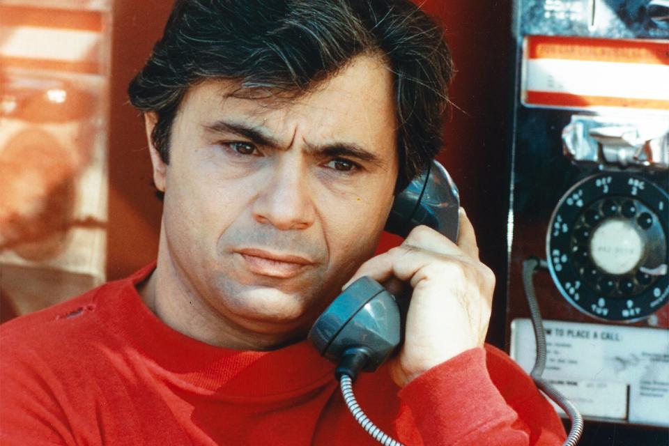 Robert Blake, US actor, wearing a red sweater as he holds a telephone receiver to his ear, beside a public payphone, in a publicity still issued for the US television series, 'Baretta', USa, circa 1976. The police drama starred Blake as 'Detetcive Tony Baretta'. (Photo by Silver Screen Collection/Getty Images)