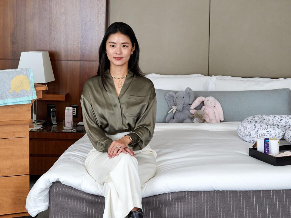 Boram Nam, the co-founder of Boram Postpartum Retreat. sits on a bed in one of the rooms available to moms who've just given birth.