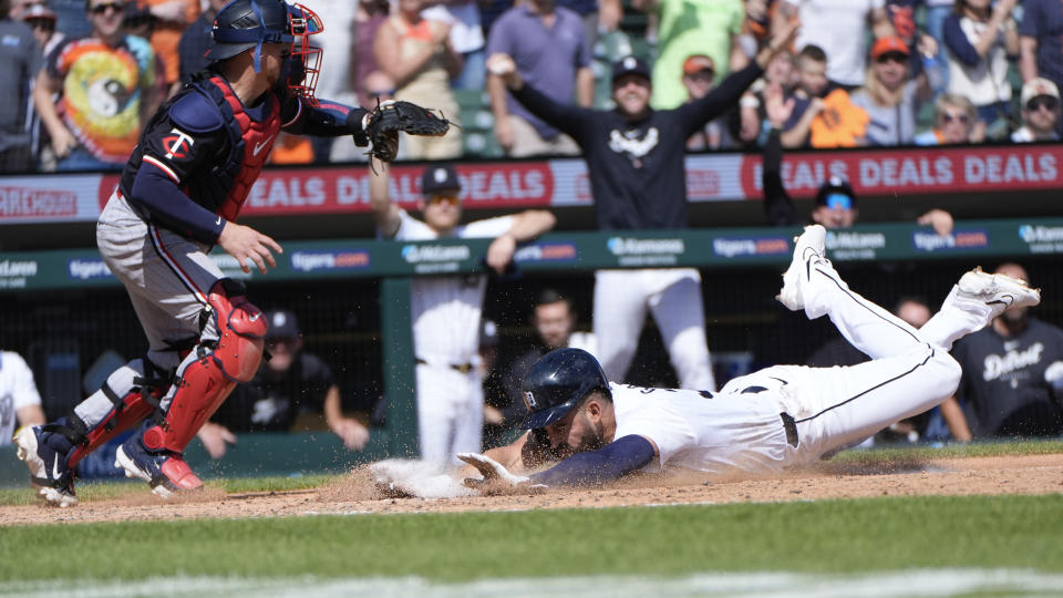 Detroit Tigers' Riley Greene (31) scores as Minnesota Twins catcher Christian Vázquez (8) waits for the throw in the eighth inning of a baseball game, Sunday, April 14, 2024, in Detroit. (AP Photo/Paul Sancya)
