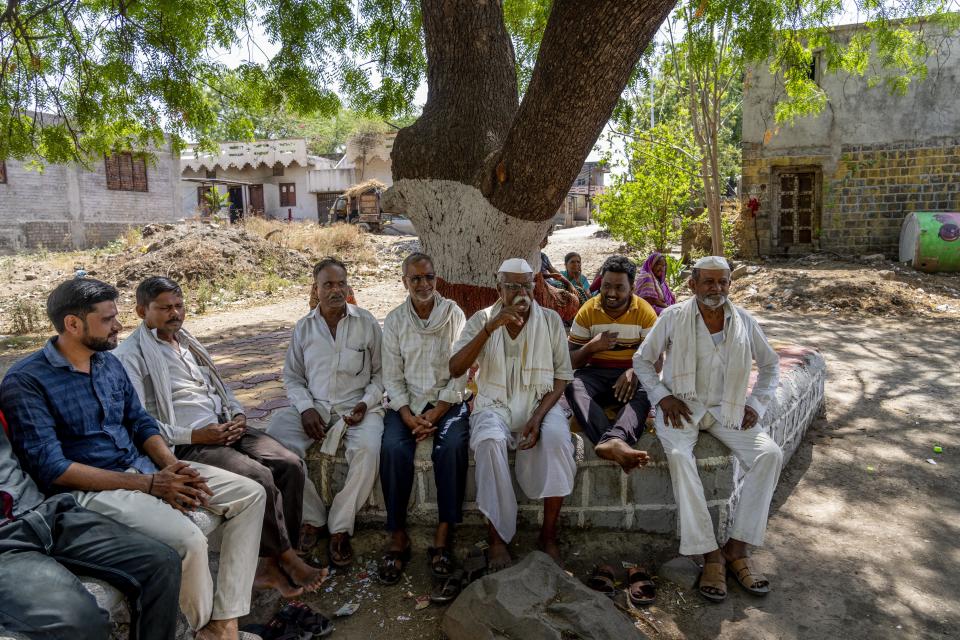 Former village head Sarjerao Gholap, third from the right, chats with fellow villagers as they sit under a tree to protect themselves from the sun during a hot summer's day in Talegaon village, Beed district, India, Friday, May 3, 2024. Gholap said politicians from various parties in the past promised to set up a canal to supply water to their village, ensure better prices for their produce and supply running water through hand pumps. He said none of these have been implemented. (AP Photo/Rafiq Maqbool)