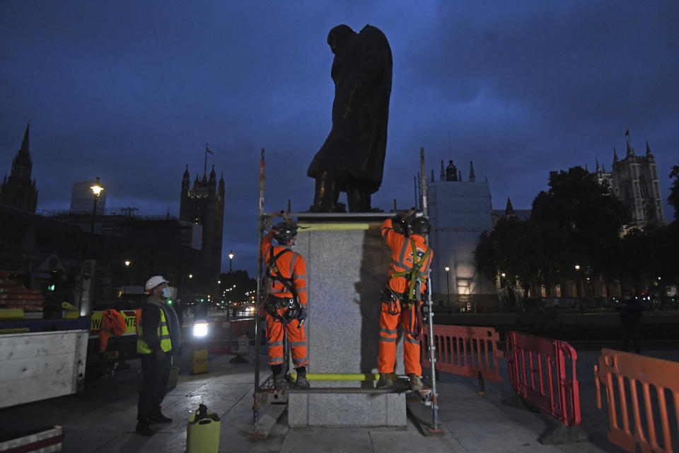 Scaffolders erect boarding around the statue of Sir Winston Churchill at Parliament Square, in London, Thursday, June 11, 2020, following Black Lives Matter protests that took place across the U.K. over the weekend. The protests were ignited by the death of George Floyd, who died after he was restrained by Minneapolis police while in custody on May 25. (Kirsty O'Connor/PA via AP)
