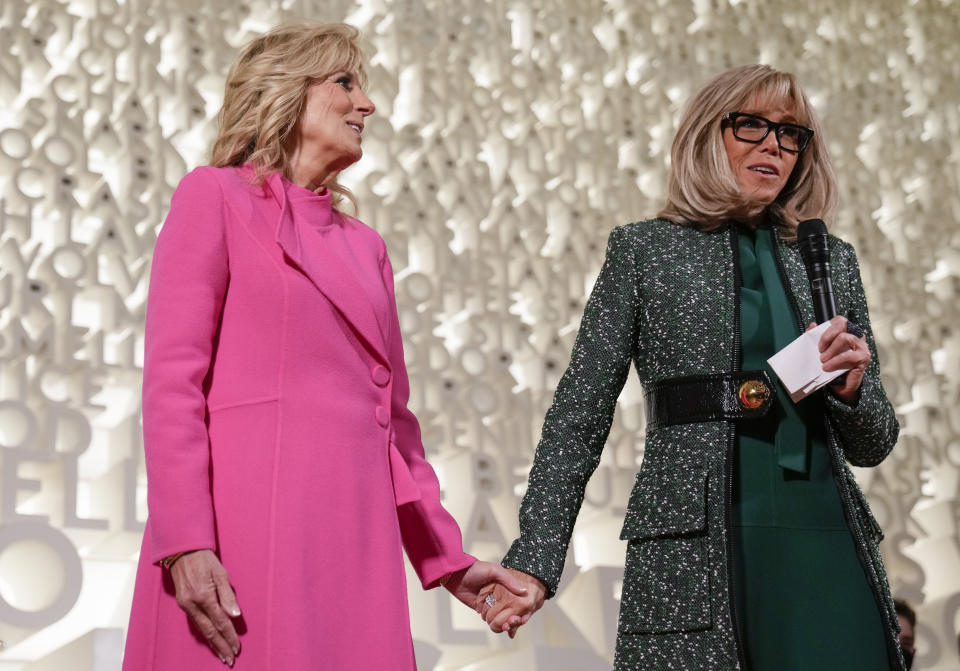 First lady Jill Biden and French President Emmanuel Macron's wife, Brigitte Macron, hold hands as they speak during a visit to Planet Word, an interactive museum, in Washington, Thursday, Dec. 1, 2022. (AP Photo/Carolyn Kaster)