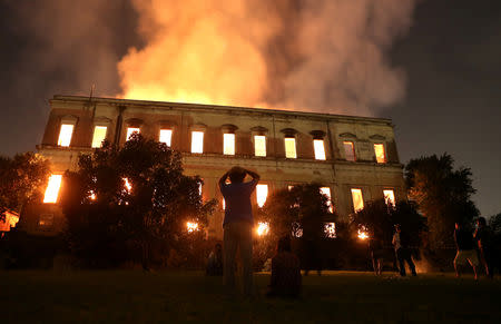 People watch as a fire burns at the National Museum of Brazil in Rio de Janeiro, Brazil September 2, 2018. REUTERS/Ricardo Moraes