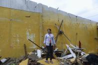 Nguyen Thi Linh stands among debris of her home, which collapsed due to Typhoon Nari, in Vietnam's central Quang Nam province, October 15, 2013. Typhoon Nari knocked down trees and damaged hundreds of houses in central Vietnam early on Tuesday, forcing the evacuation of tens of thousands of people, state media said. More than 122,000 people had been moved to safe ground in several provinces, including Quang Nam and Danang city, by late Monday before the typhoon arrived, the official Tuoi Tre (Youth) newspaper reported. (REUTERS/Duc Hien)