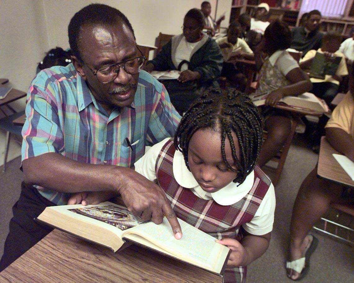 Jean-Claude Exulien, director of the Center of Information and Orientation’s after-school tutorial program, helps fourth-grader Tama Murena, 10, with her reading in 1999.