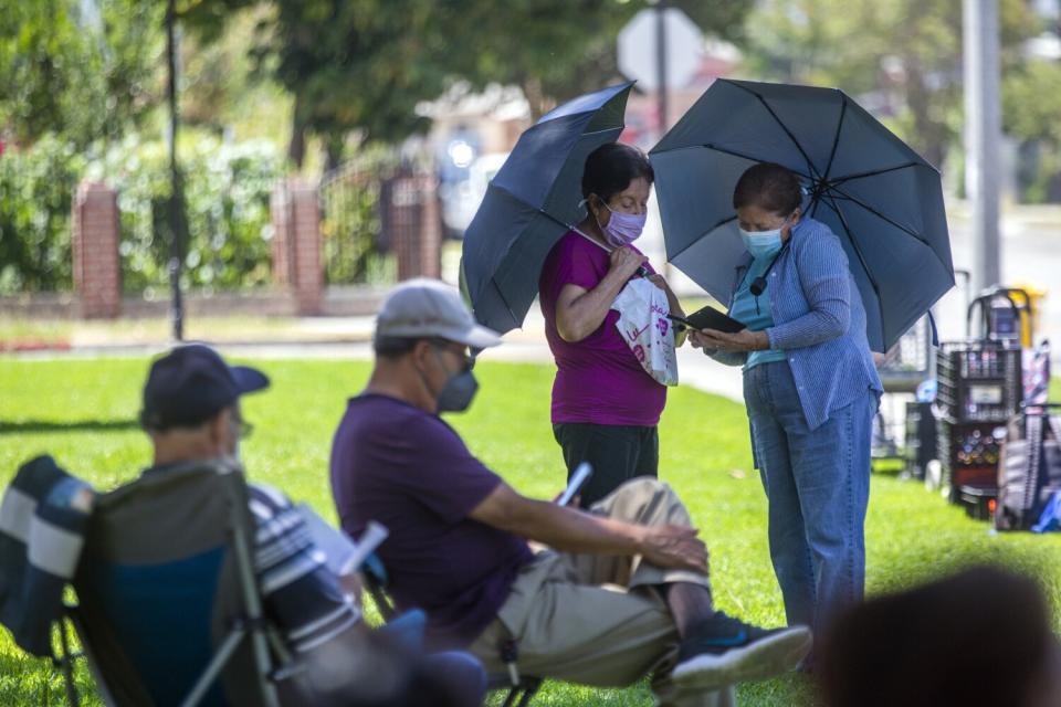 Elsa De Los Rios, 70, middle, and Pily Cuevas, 78, are standing in Tony Arceo Memorial Park