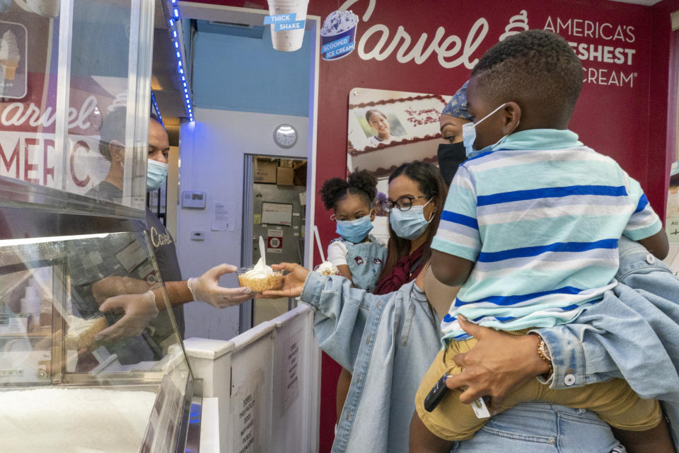 Siblings from left, Jazzmyn, Jennifer, Katherine and Zavion get ice cream at a Carvel shop, Thursday, Sept. 17, 2020, in Newark, N.J. Four-year-old Zavion and 2-year-old Jazzmyn have been taken in by the oldest of Lunisol Guzman's other three children, Katherine and Jennifer, after she died from symptoms of coronavirus. Lunisol Guzman had adopted them when she was in her 40s. (AP Photo/Mary Altaffer)