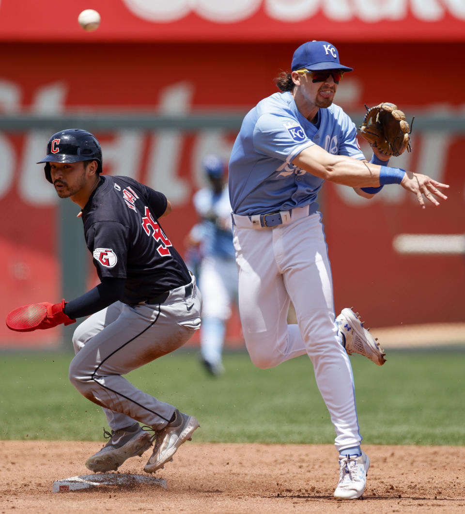Cleveland Guardians' Steven Kwan, left, is out at second base as Kansas City Royals shortstop Bobby Witt Jr., right, is late with a throw for a double play on a Daniel Schneemann single during the third inning of a baseball game in Kansas City, Mo., Sunday, June 30, 2024. (AP Photo/Colin E. Braley)