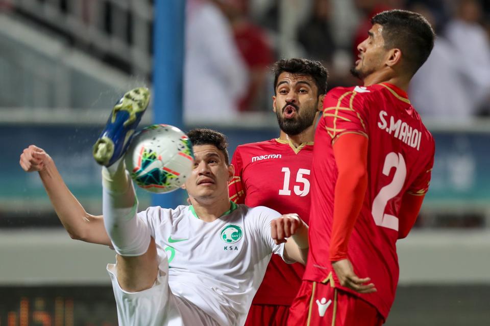 FIFA suspended Bahrain defender Sayed Baqer (right) 10 games for making a racist gesture. (Karim Jaafar/AFP/Getty Images)