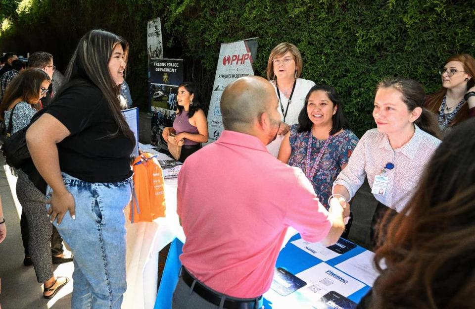 Job-seekers stop to speak to City of Fresno recruiters who were among dozens of area businesses and government agencies looking to hire during a job fair hosted by Workforce Connection and the City of Fresno in response to the laying off of 300 Fresno employees from Bitwise Industries, at Fresno City Hall on Friday, June 16. 2023. CRAIG KOHLRUSS/ckohlruss@fresnobee.com