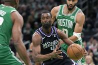 Sacramento Kings' Harrison Barnes (40) drives between Boston Celtics' Jayson Tatum (0) and Al Horford during the first half of an NBA basketball game Friday, April 5, 2024, in Boston. (AP Photo/Michael Dwyer)