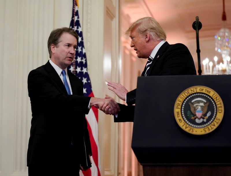 FILE PHOTO: U.S. Supreme Court Associate Justice Brett Kavanaugh talks with U.S. President Donald Trump during his ceremonial public swearing-in at the East Room of the White House in Washington