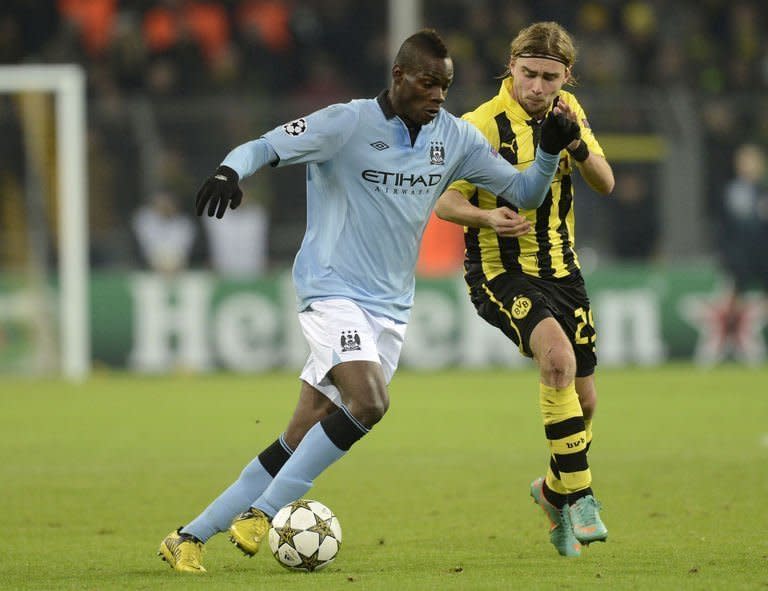 Manchester City striker Mario Balotelli (L) and Dortmund defender Marcel Schmelzer fight for the ball during their UEFA Champions League Group D football match in Dortmund. English champions City failed to save some face on Tuesday and qualify at least for the Europa League by putting up a limp performance in a 1-0 defeat