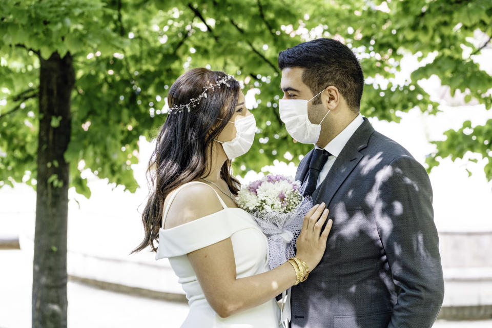 bride and groom in a face protection masks