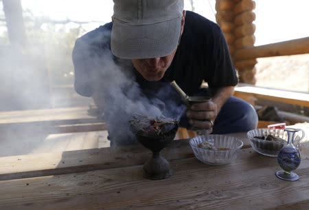 Guy Erlich, an Israeli entrepreneur, demonstrates the burning of dried and crushed resins of three plants, frankincense, myrrh and Balsam of Gilead in Kibbutz Almog, Judean desert, in the West Bank, November 30, 2017. REUTERS/Ronen Zvulun/Files