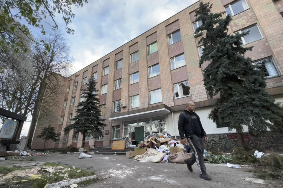 A guard walks past the entrance of 144 Yablunska Street in Bucha, Ukraine, on April 29, 2022. The office building was used as a bomb shelter before Russians took it over as a headquarters. They used it for interrogations, set up a field hospital and held civilians who didn’t pose a threat in the basement. More than a dozen bodies were found around 144 Yablunska when Russian forces retreated after their month-long occupation. (AP Photo/Erika Kinetz)