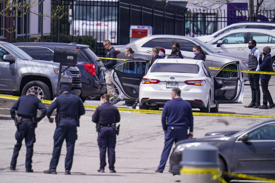 Law enforcement confer at the scene, Friday, April 16, 2021, in Indianapolis, where multiple people were shot at a FedEx Ground facility near the Indianapolis airport. (AP Photo/Michael Conroy)