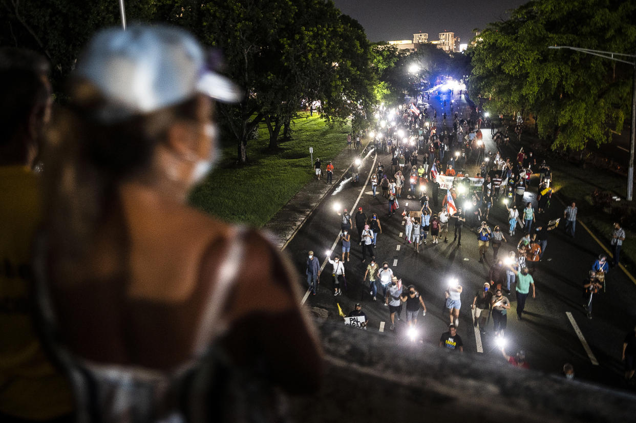 Image: People march along Las Americas Highway to protest the LUMA Energy company in San Juan, Puerto Rico on Oct. 15, 2021. (Carlos Giusti / AP)