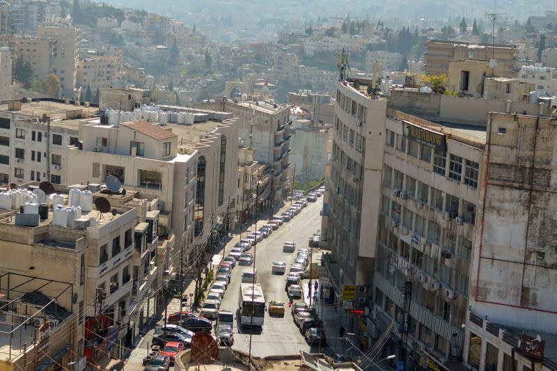 A view shows buildings as vehicles drive through a road in Amman