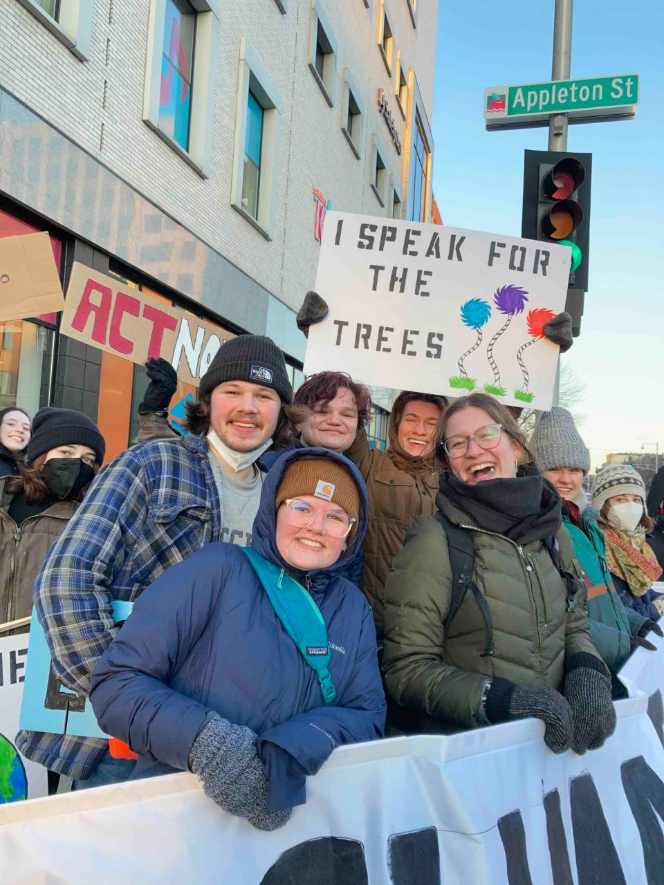 Climate activists hold up signs and banners in downtown Appleton. The rally is part of a statewide project to bring together environmental and racial justice groups to unite their efforts on climate action.