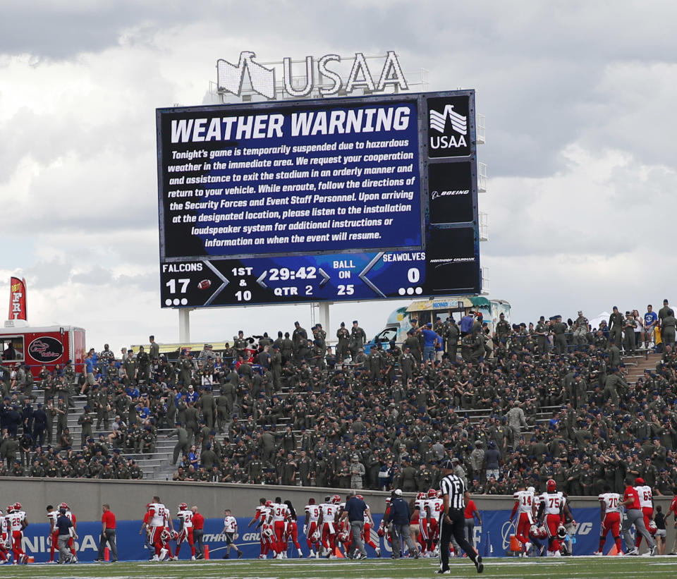 Stony Brook players file off the field as lightning forced a weather delay in the first half of an NCAA college football game against Air Force Saturday, Sept. 1, 2018, at Air Force Academy, Colo. (AP Photo/David Zalubowski)