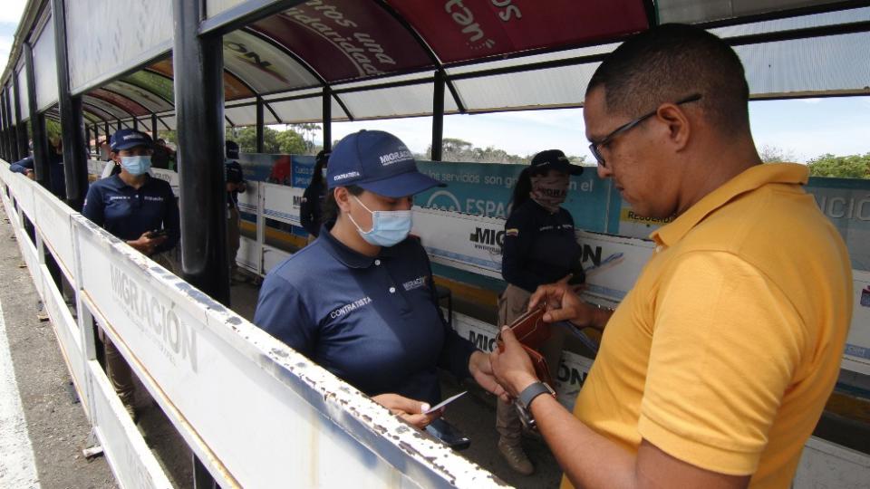 Un hombre muestra sus documentos en el cruce fronterizo