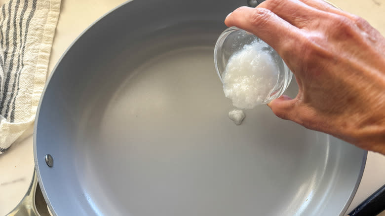 hand adding coconut oil