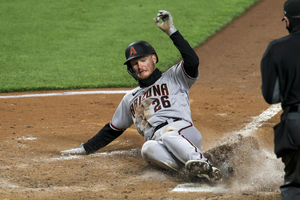 Pavin Smith, de los Diamondbacks de Arizona, anota en el décimo inning del juego ante los Rojos de Cincinnati, el miércoles 21 de abril de 2021 (AP Photo/Aaron Doster)