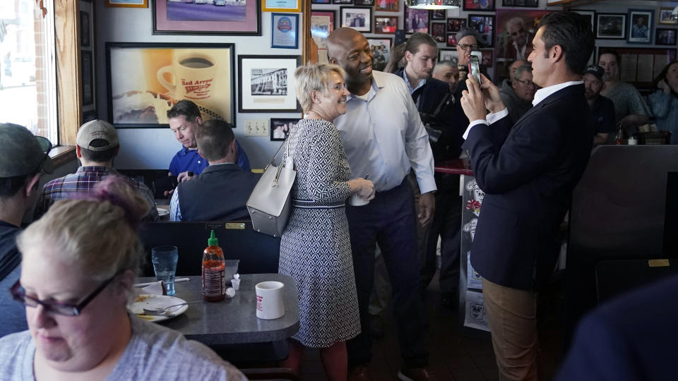 Sen. Tim Scott, R-S.C., poses for a selfie with diners during a visit to the Red Arrow Diner, Thursday, April 13, 2023, in Manchester, N.H. Scott on Wednesday launched an exploratory committee for a 2024 GOP presidential bid, a step that comes just shy of making his campaign official. (AP Photo/Charles Krupa)
