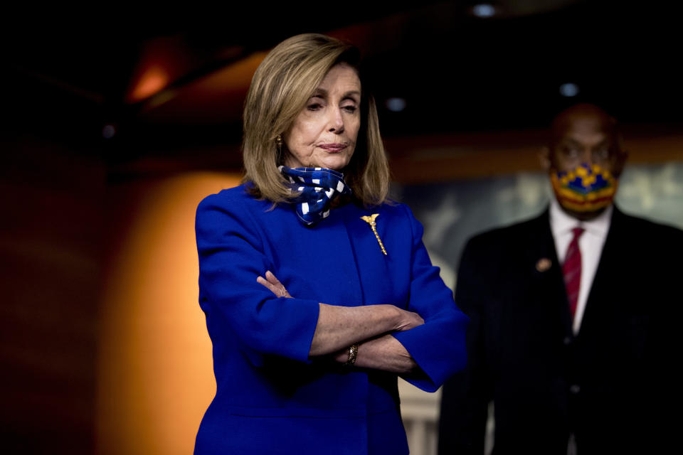 House Speaker Nancy Pelosi of Calif., left, accompanied by Rep. Dwight Evans, D-Pa., right, listens to a question from a reporter during a news conference on Capitol Hill in Washington, Friday, July 24, 2020, on the extension of federal unemployment benefits. (AP Photo/Andrew Harnik)