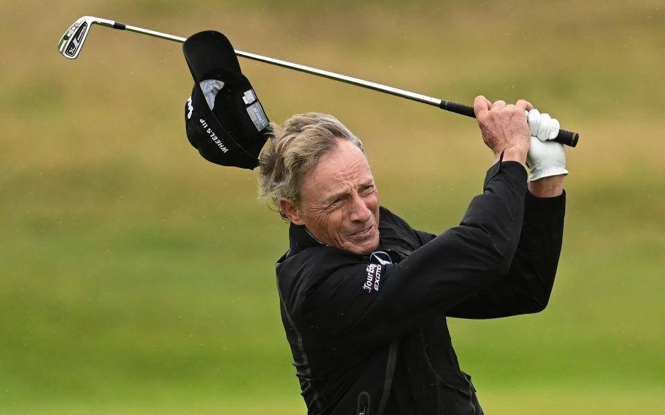 Bernhard Langer cap goes for a trip as the wind, which was strong at 40mph, made life hell for some of the world&#39;s best