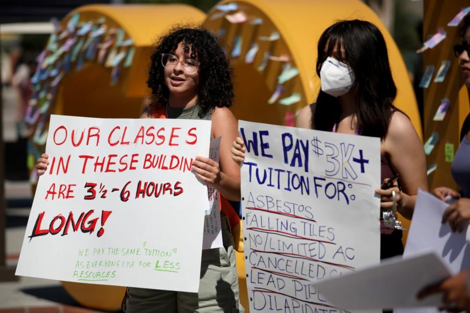 Students hold protest signs at Cal State Long Beach.