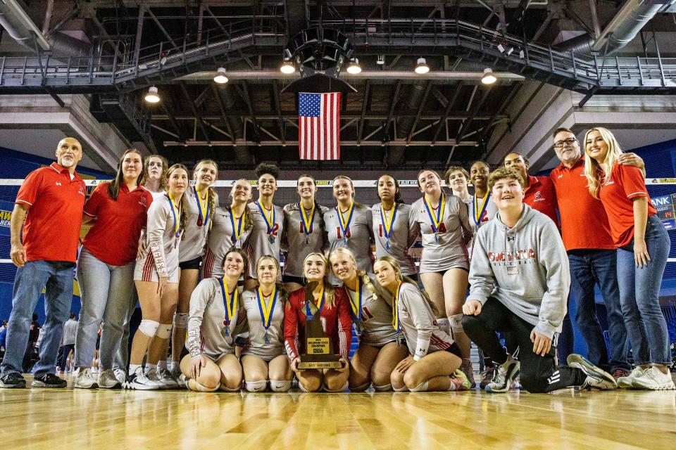 The Smyrna High School team poses for a photo with their trophy after defeating Ursuline Academy 25-14 during the DIAA Girls Volleyball Tournament championship game at the Bob Carpenter Center in Newark, Thursday, Nov. 16, 2023.