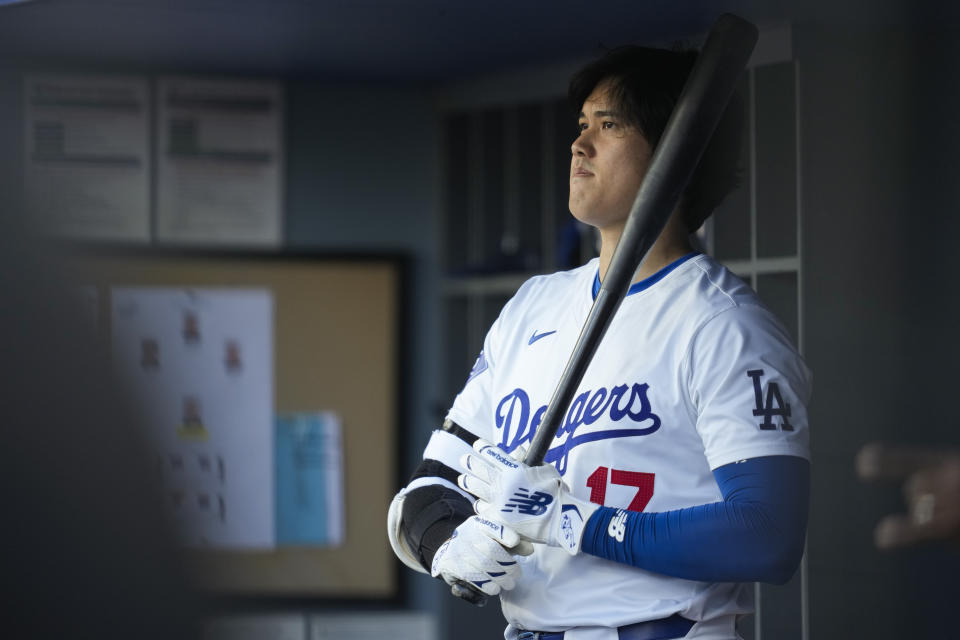 Los Angeles Dodgers designated hitter Shohei Ohtani stands in the dugout during the first inning of a baseball game against the Atlanta Braves in Los Angeles, Saturday, May 4, 2024. (AP Photo/Ashley Landis)