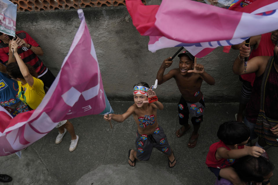 Young supporters of Brazil's former President Luiz Inacio Lula da Silva, who is running for office again, flash the letter L for "Lula" during a campaign rally with him in the Complexo do Alemao favela in Rio de Janeiro, Brazil, Wednesday, Oct. 12, 2022. The presidential run-off election is set for Oct. 30. (AP Photo/Silvia Izquierdo)