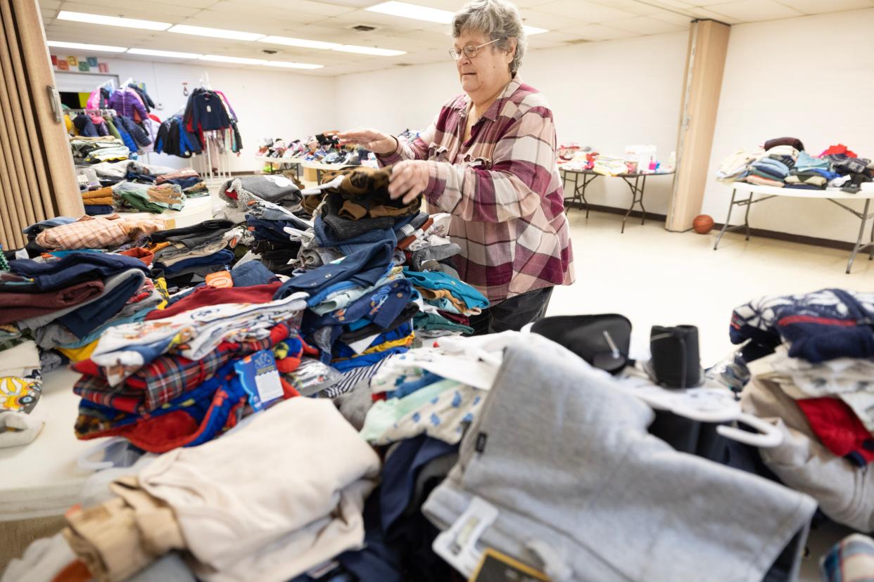 Clara Ward, a volunteer with the Alliance Salvation Army, sets out clothing for the organization's annual Christmas distribution.
