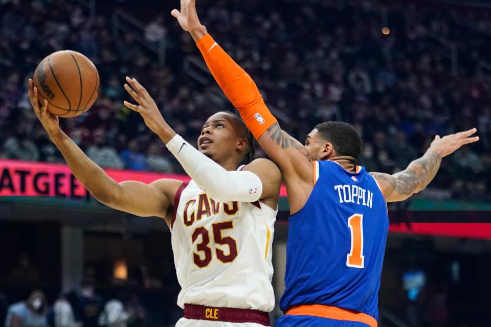 Cleveland Cavaliers' Isaac Okoro (35) drives to the basket against New York Knicks' Obi Toppin (1) in the first half of an NBA basketball game, Monday, Jan. 24, 2022, in Cleveland. (AP Photo/Tony Dejak)