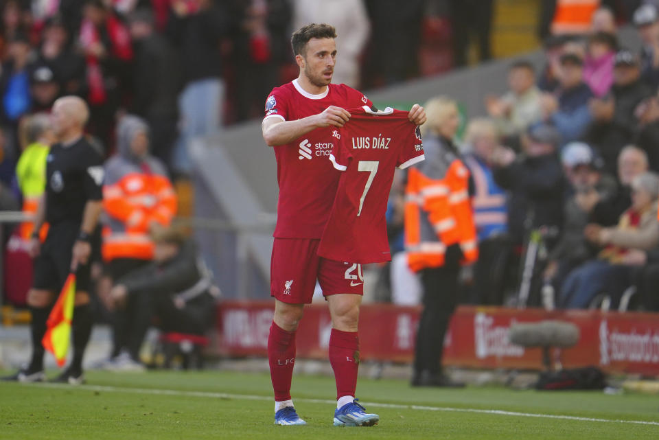 Liverpool's Diogo Jota celebrates after scoring his side's opening goal holding the jersey of teammate Luis Diaz during the English Premier League soccer match between Liverpool and Nottingham Forest, at Anfield in Liverpool, England, Sunday, Oct. 29, 2023. Colombian police continued their search for the father of Liverpool striker Luis Díaz on Sunday, one day after he was kidnapped with his wife near the country's border with Venezuela. (AP Photo/Jon Super)