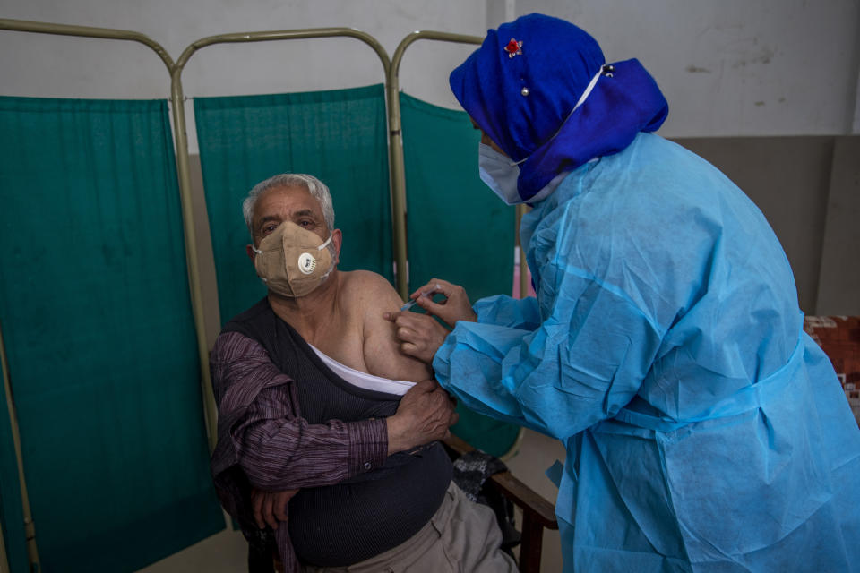 An elderly Kashmiri Mohammad Amin receives the Covishield vaccine for COVID-19 at a primary health center in Srinagar, Indian controlled Kashmir, Friday, March 19, 2021. India is third behind the United States and Brazil in total coronavirus infections. (AP Photo/Dar Yasin)