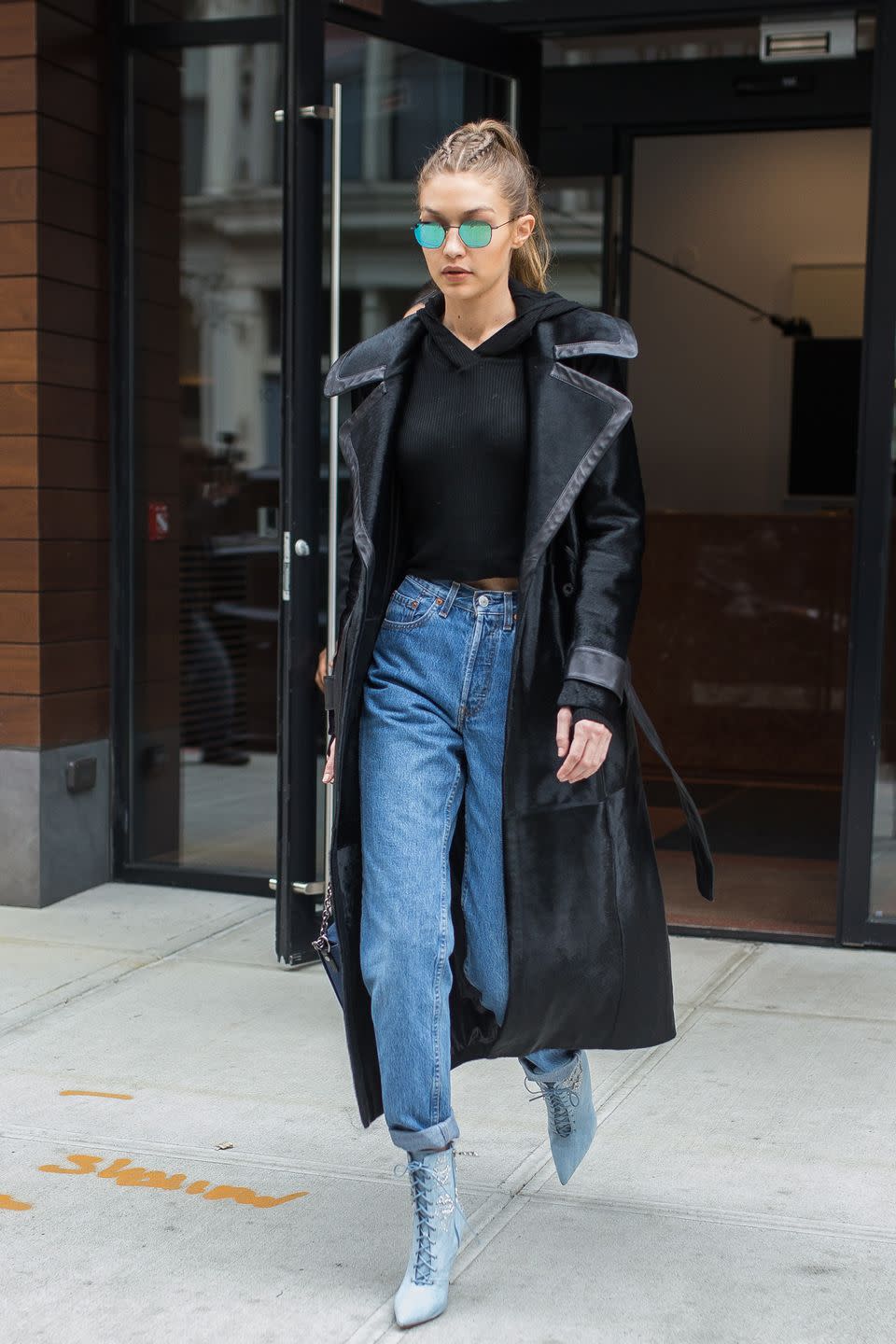 <p>In a black leather-lined coat, cropped hoodie, high-waited rolled jeans, Rihanna x Manolo lace-up ankle boots and reflective Krewe sunglasses while out in New York. </p>