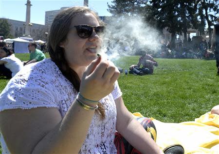 A woman exhales marijuana smoke during the 4/20 Rally at the Civic Center in Denver, Colorado, April 20, 2014. REUTERS/Mark Leffingwell